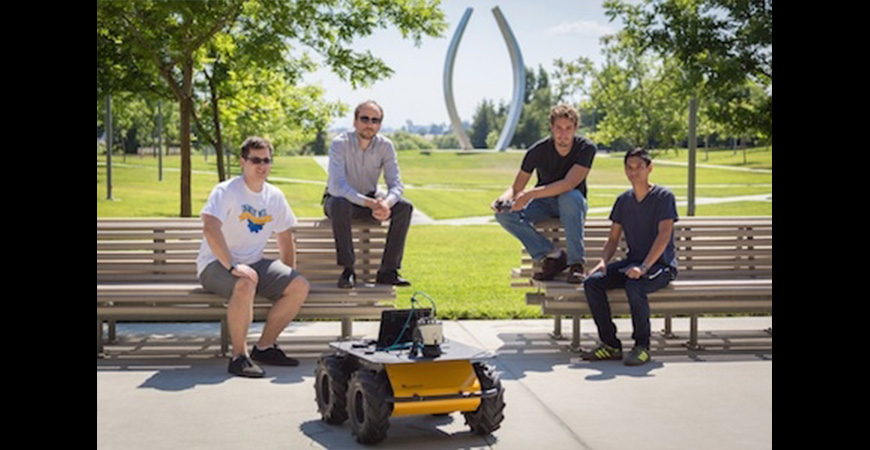students sitting on the bench in front of their robot